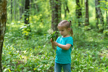 little girl in the forest with a bouquet of lilies of the valley