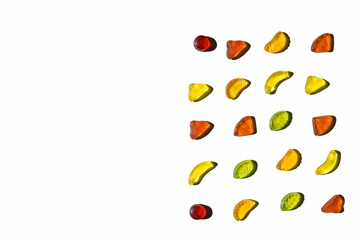 Colorful jelly beans in fruits shapes. Top view of positive and sweet composition on white background with copy space.