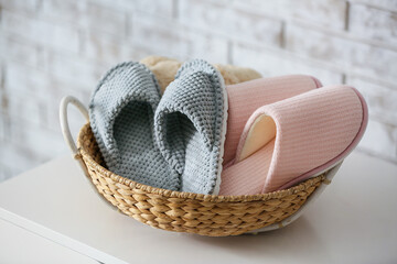 Basket with soft slippers on table
