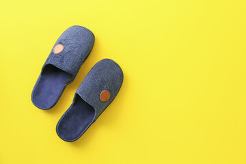 Pair of soft slippers on color background
