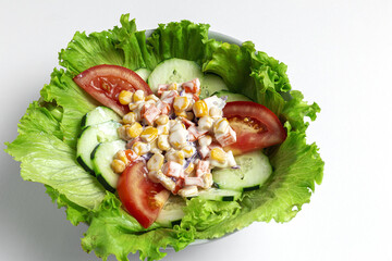 Fresh lettuce salad with tomatoes, red onion, corn, carrots, cucumber