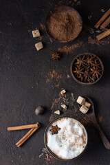 Hot chocolate or hot cocoa with anise star and cinnamon sticks over dark texture background. Selective focus.