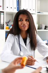 Female medicine doctor hand hold jar of pills and write prescription to patient at worktable. Panacea and life save, prescribing treatment, legal drug store concept. Empty form ready to be used