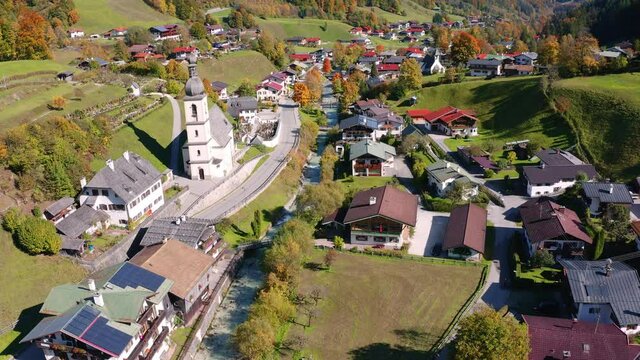 4k drone flight down footage (Ultra High Definition).  Sunny morning scene of Parish Church of St. Sebastian. Picturesque autumn view of Bavarian Alps, Ramsau village, Germany, Europe.
