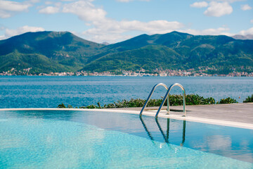 Reflecting the mountains, sea and sky in the smooth water of the pool.