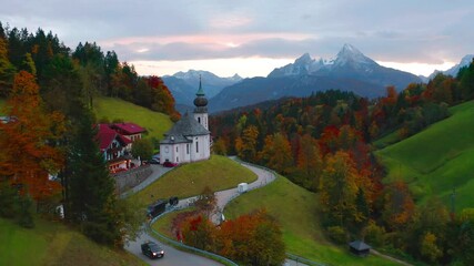 4k drone forward video (Ultra High Definition) of Maria Gern church with Hochkalter peak on background. Wonderful autumn sunset on Bavaria Alps. Majestic evening landscape of Germany countryside.
