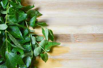 fresh curry leafs on wood chopping board for cooking