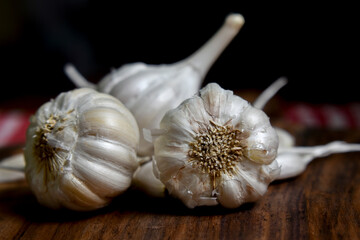 garlic and garlic cloves on wooden chopping board