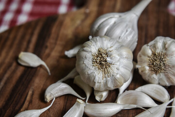 garlic and garlic cloves on wooden chopping board