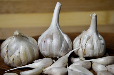 garlic and garlic cloves on wooden chopping board