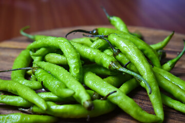 fresh green chilies on chopping board for spicy vegetable 