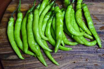 fresh green chilies on chopping board for spicy vegetable 