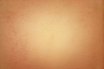 Beige colored abstract background with light glow and fine texture.