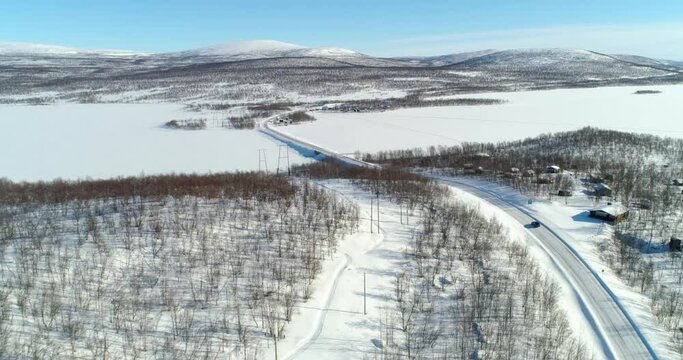 Car on a arctic road, C4k aerial, drone shot, following a vehicle, driving on route e8 the kasivarrentie, towards a bridge, in Kasivarren eramaa, Enontekio, Lapland, Finland