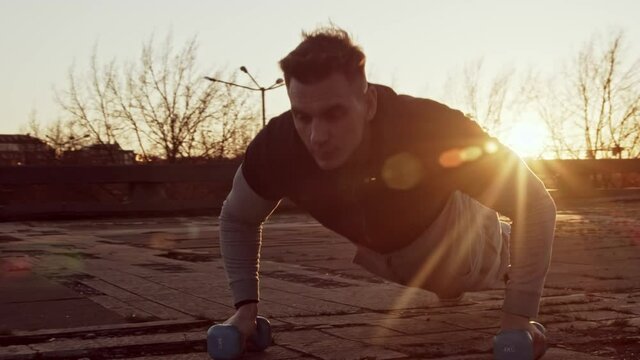 Young and fit man having evening workout outdoor. Urban sunset background. Fitness and sport.