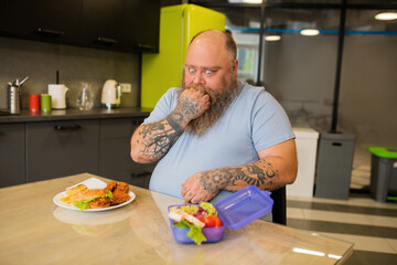 Thinking man with funny grimace near the food