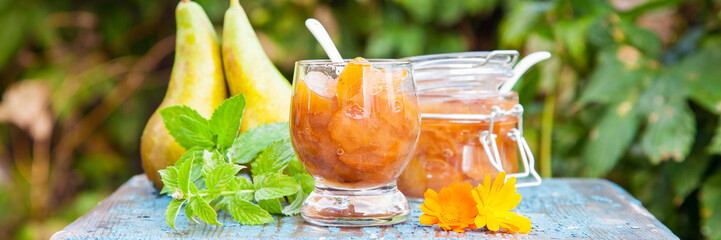 Homemade Pear jam in a jar on a table, selective focus. Long size. Vegan sweets
