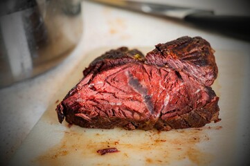 Sliced piece of baked beef (hanger steak) on kitchen board.