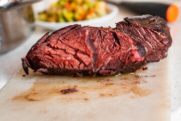 Detail view of nice structure of meat on baked hanger steak on kitchen board