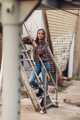 Portrait einer jungen Frau in Bluse und Jeans in einem Lost Place