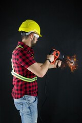 Construction Worker drills with a large demolition hammer  on black background.Construction worker...