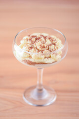 Delicious tiramisu dessert served in tall glass over rustic wooden background. Traditional Italian dessert.