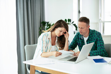 Husband and wife preparing bills to pay. Young couple having financial problems.