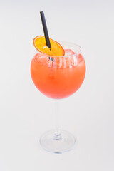 Cold summer alcohol cocktail with ice and orange in a tall wine glass isolated on white background.