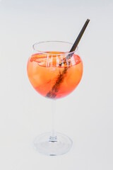 Cold summer alcohol cocktail with ice and orange in a tall wine glass isolated on white background.