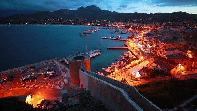 Illuminated evening cityscape of Calvi port. Great summer scene of Corsica island, France, Europe. Mediterranean  seascape. Traveling concept background. Full HD video (High Definition).
