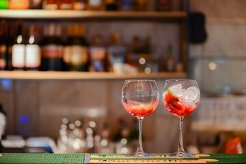 Fresh drinks strawbrerry Mojito with lime and ice in two clear glasses on a table in bar with copy space. Copy space.
