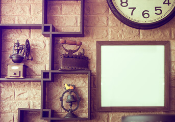 The old style of clock, iron, coffee grinder, handbell, and white frame for putting alphabets on the brown tile background. Vintage color tone.
