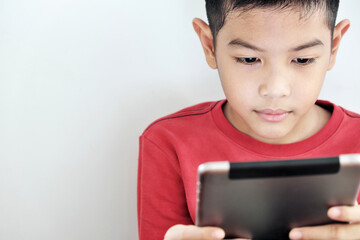 A boy playing a tablet on a white background