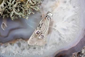 Fashionable ornamental crystal quartz silver decoration pendant on grey agate background