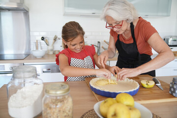 Grandmother with grandkid making apple pie