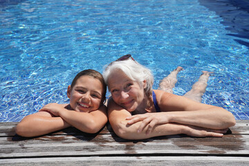 Grandmother with grandkid in resort swimming-pool
