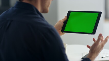 Closeup business man making video call on green screen tablet.
