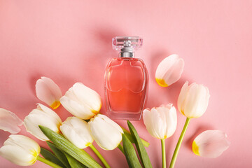 Beautiful perfume bottle and tender white tulips