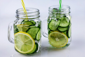 Cold drink, two retro glass cup of lemonade with cucumber and lemon on a white background, shallow depth of field, selective focus. Health drink concept.