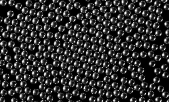 Steel BBs, metal pellets isolated on black background, top view