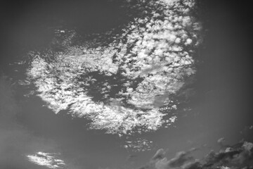 a heart-shaped cloud in the blue sky and a plane