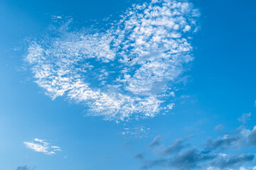 a heart-shaped cloud in the blue sky and a plane
