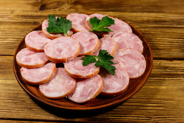 Ham sausage on a plate on wooden table