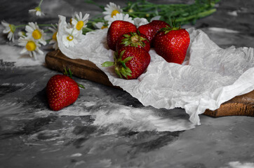 fresh strawberries on a light background with daisies