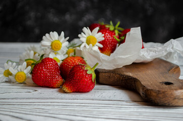 fresh strawberries on a light background with daisies