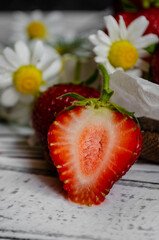 fresh strawberries on a light background with daisies