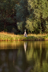 Pond on a sunny day. Wigwam on the other shore. Lake in the forest. Green fairy tale. High quality photo
