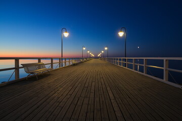 Fototapeta na wymiar Pier during sunrise - day and night