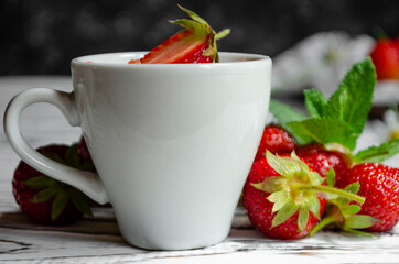 strawberry yogurt in a white cup with mint and fresh strawberries