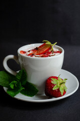 strawberry yogurt in a white cup with mint and fresh strawberries